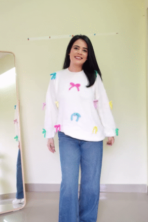 Soft White Fleece Pullover Sweatshirt with Multicolor 3D Bow AppliquΓ© Embellishments and Relaxed Balloon Sleeves Paired with Classic Blue Wide-Leg Denim Jeans